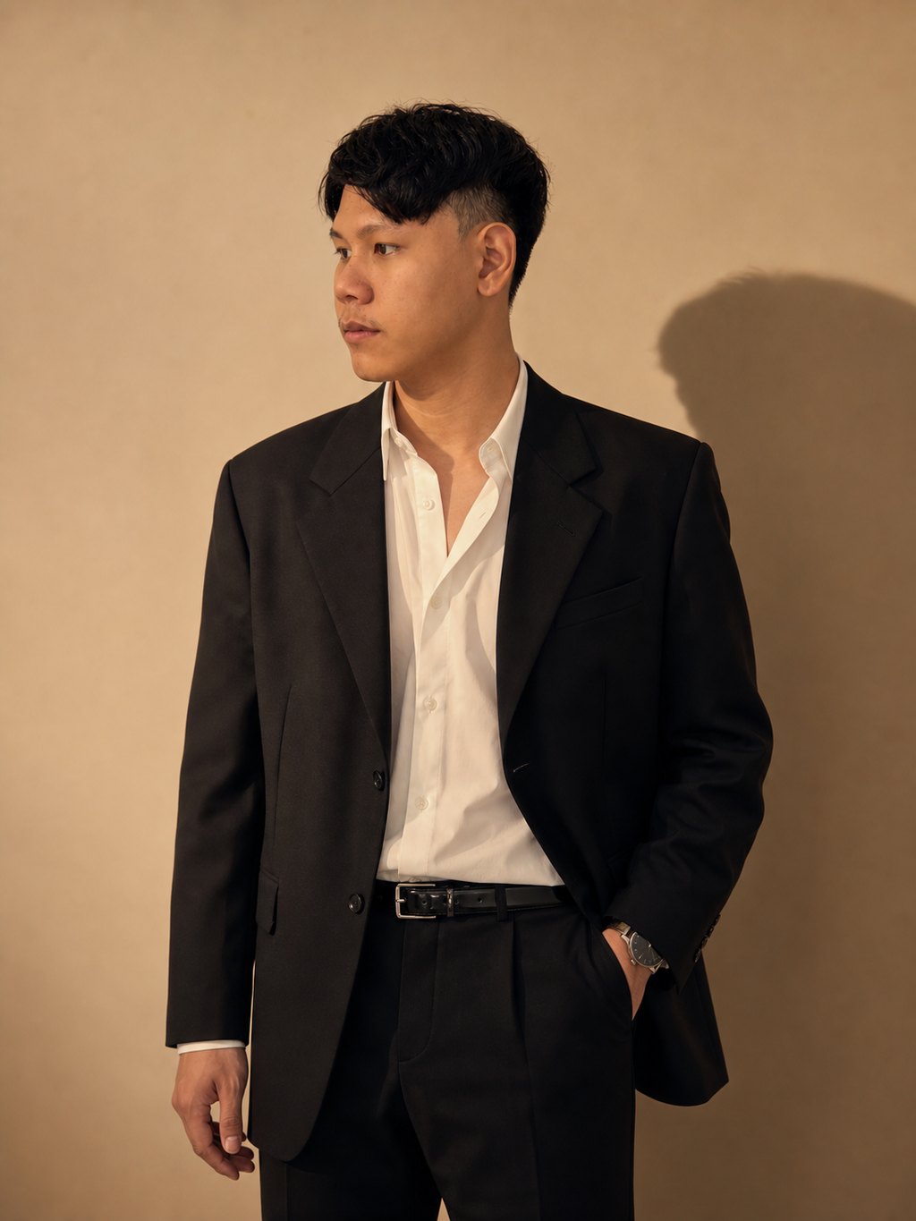 รูป AI เบลเซอร์ดำ แสงทองบนผนังเบจ